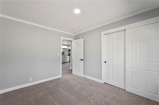 2101 Spruce St, Leavenworth, KS 66048 - unfurnished bedroom featuring stainless steel refrigerator with ice dispenser, carpet, crown molding, a closet, and a textured ceiling