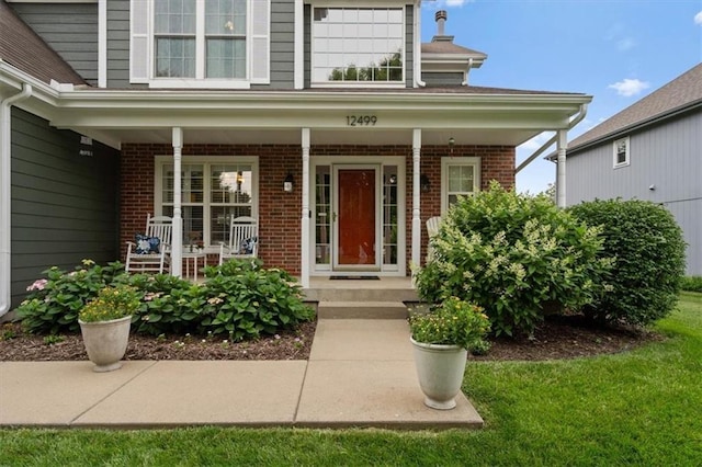 12499 S Marion St, Olathe, KS 66061 - view of exterior entry with a porch and brick siding