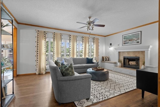 12499 S Marion St, Olathe, KS 66061 - living area with crown molding, a ceiling fan, wood finished floors, a textured ceiling, and a fireplace
