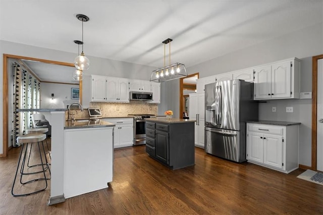 12499 S Marion St, Olathe, KS 66061 - kitchen featuring appliances with stainless steel finishes, white cabinetry, decorative backsplash, and a peninsula