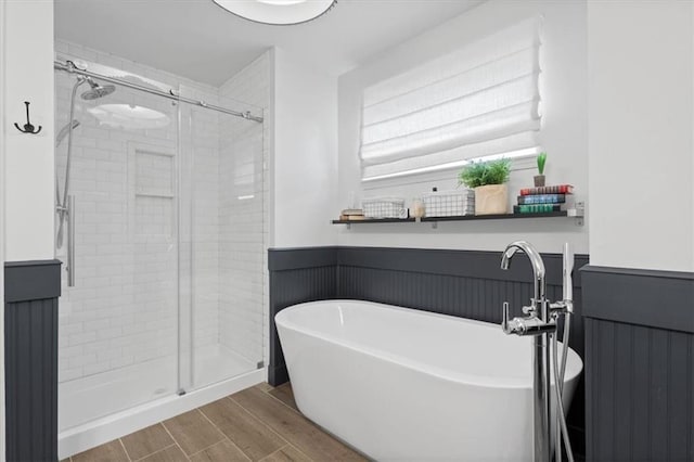 12499 S Marion St, Olathe, KS 66061 - full bathroom featuring a freestanding bath, a shower stall, wainscoting, and wood finished floors