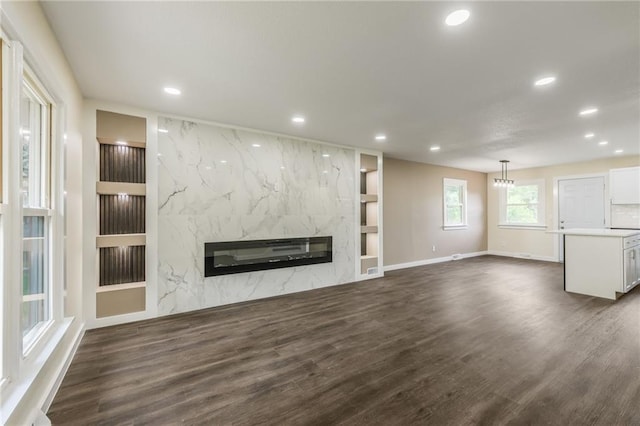 729 S Central St, Olathe, KS 66061 - unfurnished living room with recessed lighting, built in features, a fireplace, and dark wood-style floors