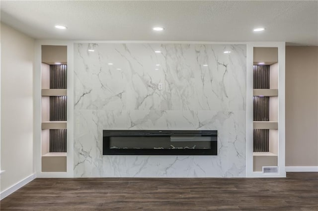 729 S Central St, Olathe, KS 66061 - detailed view of a premium fireplace, built in features, recessed lighting, a textured ceiling, and wood finished floors