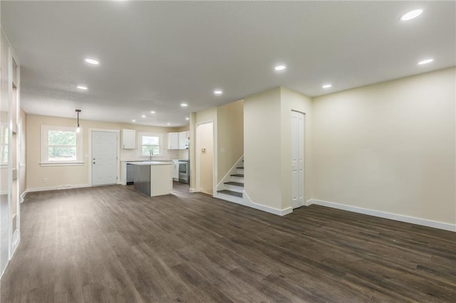 729 S Central St, Olathe, KS 66061 - unfurnished living room featuring dark wood finished floors, recessed lighting, and stairway