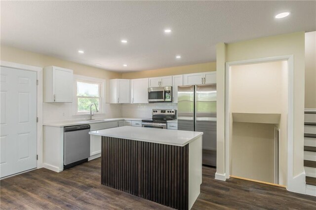 729 S Central St, Olathe, KS 66061 - kitchen with appliances with stainless steel finishes, white cabinets, dark wood-type flooring, light countertops, and decorative backsplash