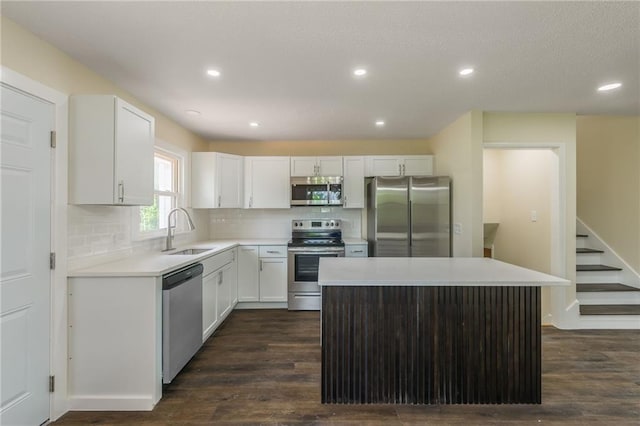 729 S Central St, Olathe, KS 66061 - kitchen featuring appliances with stainless steel finishes, a kitchen island, dark wood-style floors, white cabinetry, and recessed lighting