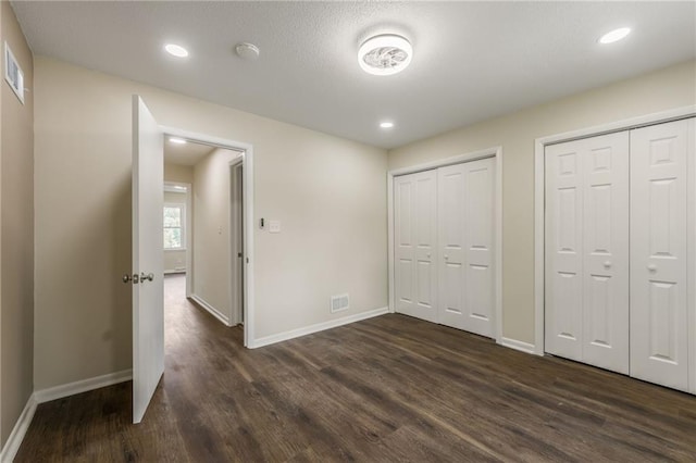729 S Central St, Olathe, KS 66061 - unfurnished bedroom featuring dark wood-style flooring, multiple closets, and recessed lighting