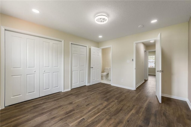 729 S Central St, Olathe, KS 66061 - unfurnished bedroom featuring two closets, dark wood-style floors, a textured ceiling, recessed lighting, and connected bathroom