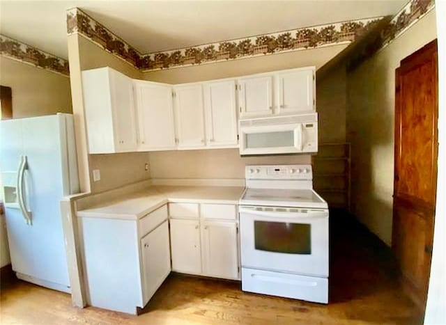 320 W Walnut St, Nevada, MO 64772 - kitchen with white appliances, light countertops, white cabinetry, and light wood-type flooring