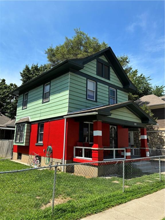 5223 Wilburn Ct, Kansas City, MO 64123 - view of front of home with a fenced front yard, a porch, and brick siding