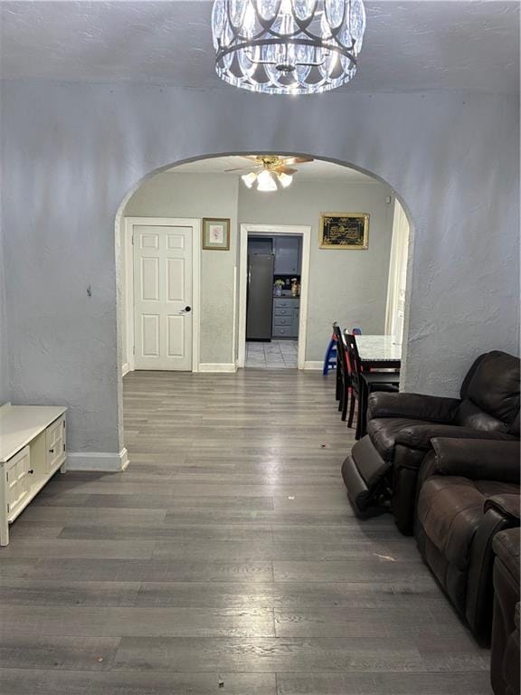 4123 E 6th St, Kansas City, MO 64124 - living room with arched walkways, wood finished floors, a ceiling fan, and a chandelier