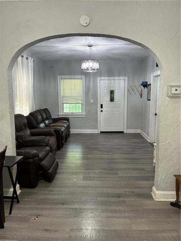 4123 E 6th St, Kansas City, MO 64124 - entrance foyer featuring a textured wall, wood finished floors, arched walkways, and a chandelier