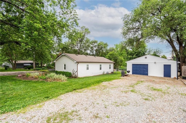 118 Village St, Tonganoxie, KS 66086 - view of side of home with a garage, an outdoor structure, and a lawn