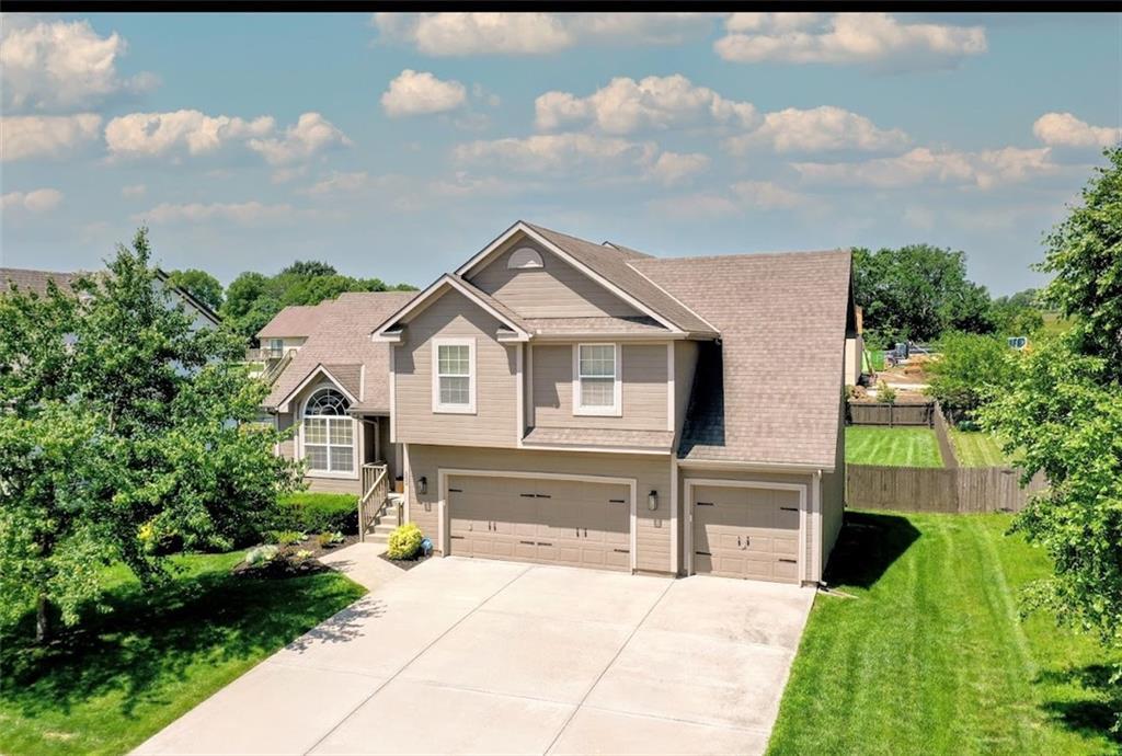 502 River Birch Rd, Raymore, MO 64083 - view of front facade featuring a garage and driveway