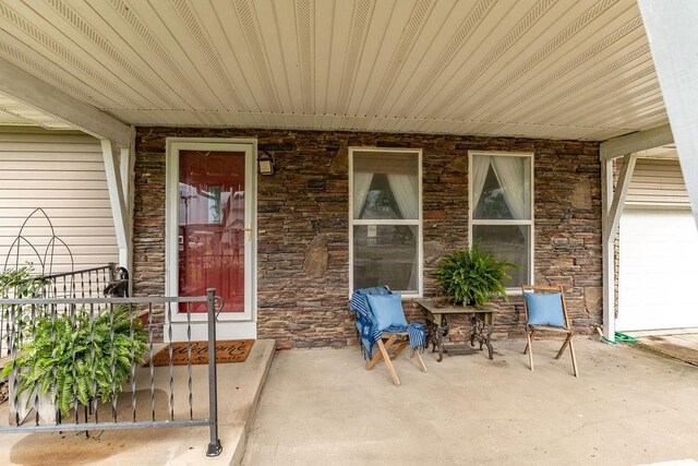 106 S Clark St, Adrian, MO 64720 - doorway to property featuring stone siding and a porch
