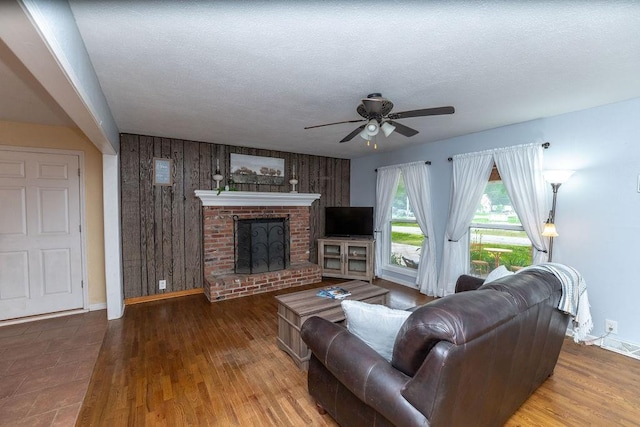 106 S Clark St, Adrian, MO 64720 - living area with a ceiling fan, a fireplace, wood walls, and wood finished floors