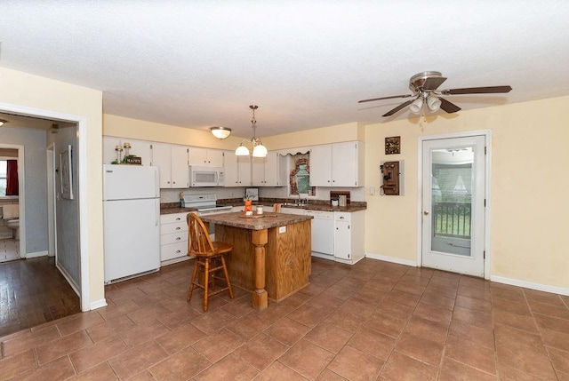106 S Clark St, Adrian, MO 64720 - kitchen with white appliances, white cabinetry, dark countertops, and a kitchen island