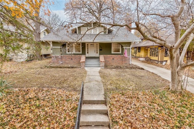 5740 Oak St, Kansas City, MO 64113 - bungalow-style home featuring a porch, a shingled roof, and brick siding