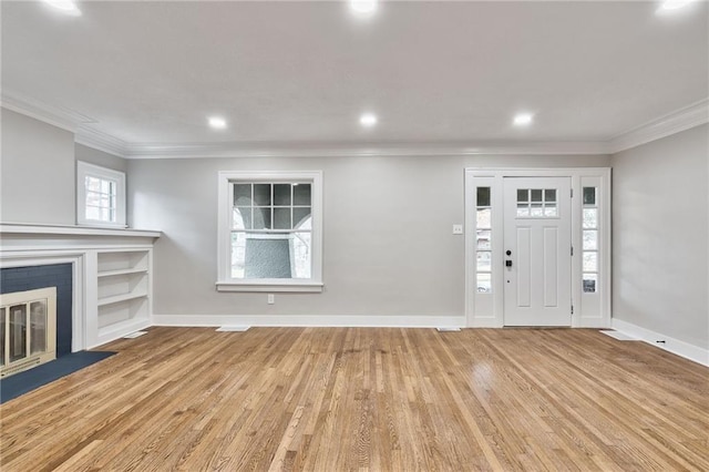 5740 Oak St, Kansas City, MO 64113 - entryway with crown molding, wood finished floors, a glass covered fireplace, and recessed lighting