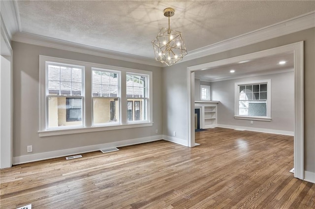 5740 Oak St, Kansas City, MO 64113 - unfurnished living room featuring ornamental molding, a chandelier, wood finished floors, a fireplace with flush hearth, and a textured ceiling