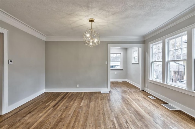 5740 Oak St, Kansas City, MO 64113 - unfurnished dining area featuring a chandelier, wood finished floors, a textured ceiling, and ornamental molding
