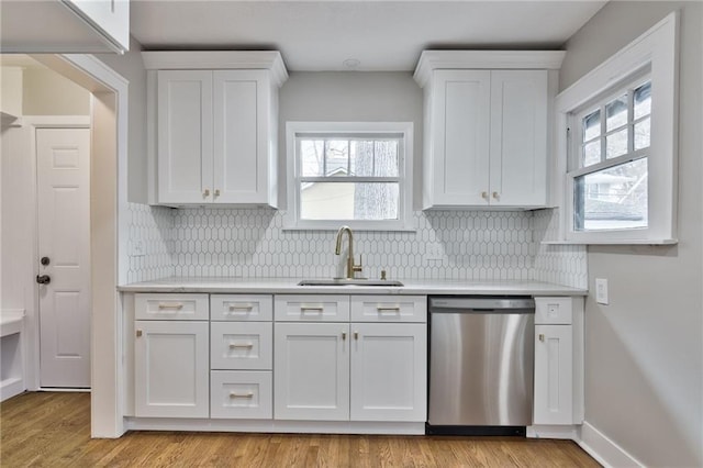 5740 Oak St, Kansas City, MO 64113 - kitchen featuring stainless steel dishwasher, light countertops, white cabinetry, and tasteful backsplash