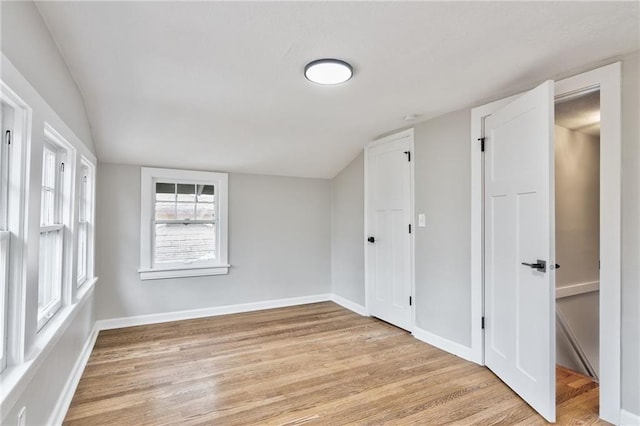 5740 Oak St, Kansas City, MO 64113 - unfurnished bedroom featuring lofted ceiling and light wood-style floors