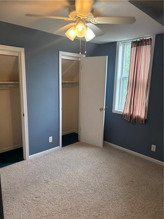 201 W Royle St, Richmond, MO 64085 - unfurnished bedroom featuring two closets, carpet floors, and a ceiling fan