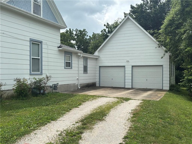 201 W Royle St, Richmond, MO 64085 - view of side of home with driveway, a garage, and a lawn