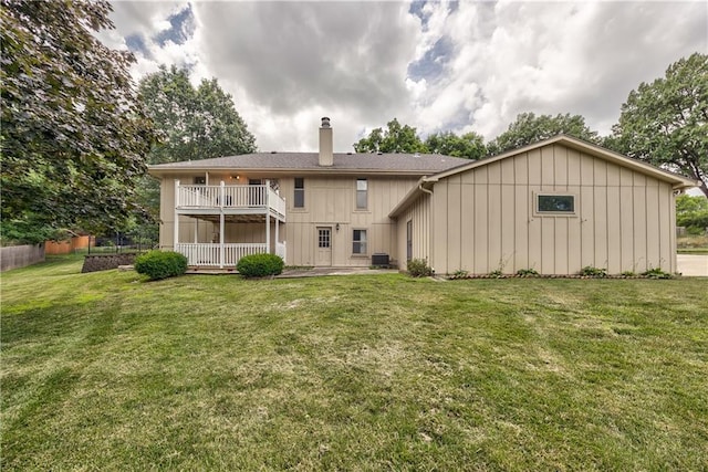 10706 W 50th Ter, Shawnee, KS 66203 - rear view of house with a chimney, board and batten siding, a balcony, and a lawn