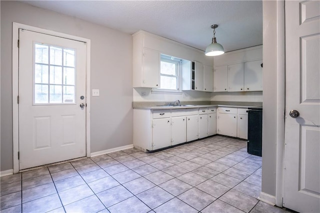 531 S Cedar Ave, Independence, MO 64053 - kitchen with white cabinets, light tile patterned floors, decorative light fixtures, light countertops, and a textured ceiling