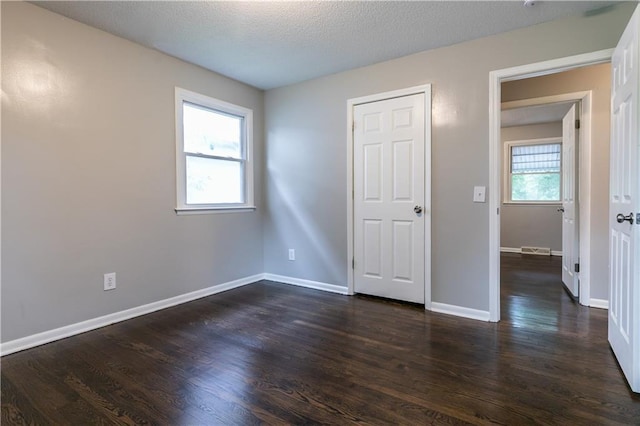 531 S Cedar Ave, Independence, MO 64053 - unfurnished bedroom with dark wood-style flooring and a textured ceiling