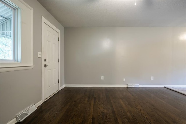 531 S Cedar Ave, Independence, MO 64053 - spare room featuring dark wood-type flooring and a textured ceiling