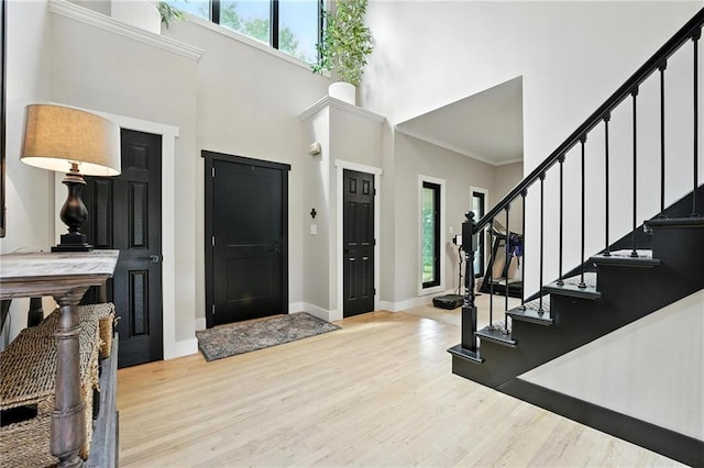 15376 Loring Rd, Bonner Springs, KS 66012 - foyer featuring healthy amount of natural light, a high ceiling, wood finished floors, stairway, and ornamental molding