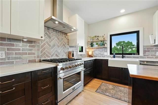 15376 Loring Rd, Bonner Springs, KS 66012 - kitchen featuring appliances with stainless steel finishes, wall chimney range hood, light countertops, white cabinetry, and recessed lighting