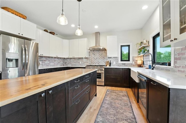 15376 Loring Rd, Bonner Springs, KS 66012 - kitchen with stainless steel appliances, wall chimney exhaust hood, white cabinets, glass insert cabinets, and light wood-type flooring