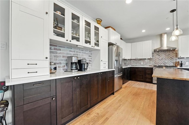 15376 Loring Rd, Bonner Springs, KS 66012 - kitchen with wall chimney exhaust hood, stainless steel appliances, white cabinets, tasteful backsplash, and glass insert cabinets