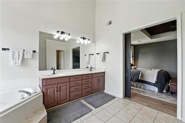 15376 Loring Rd, Bonner Springs, KS 66012 - bathroom with double vanity, a towering ceiling, tile patterned floors, a garden tub, and connected bathroom