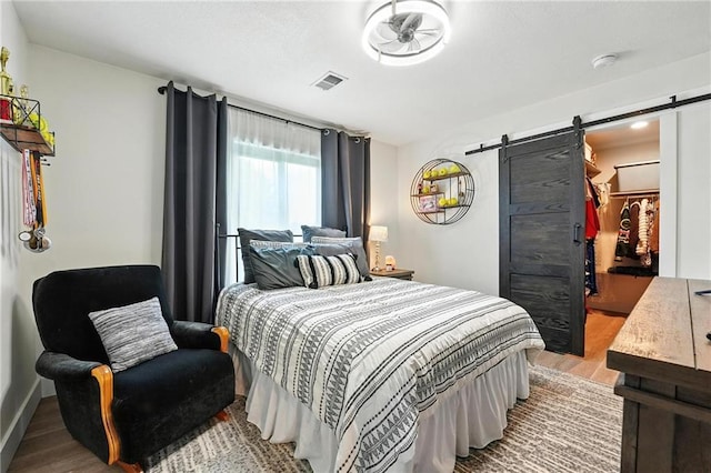 15376 Loring Rd, Bonner Springs, KS 66012 - bedroom featuring a barn door, light wood finished floors, and a walk in closet