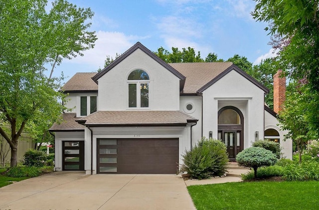 8148 Lingle Ln, Lenexa, KS 66215 - view of front of house with an attached garage, stucco siding, driveway, a shingled roof, and french doors