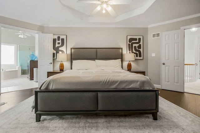 8148 Lingle Ln, Lenexa, KS 66215 - bedroom featuring wood finished floors, a tray ceiling, a ceiling fan, crown molding, and ensuite bathroom