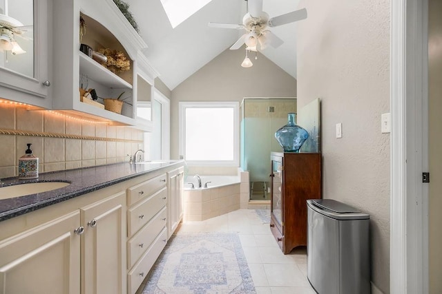 8148 Lingle Ln, Lenexa, KS 66215 - bathroom with ceiling fan, double vanity, a garden tub, vaulted ceiling, and tile patterned floors