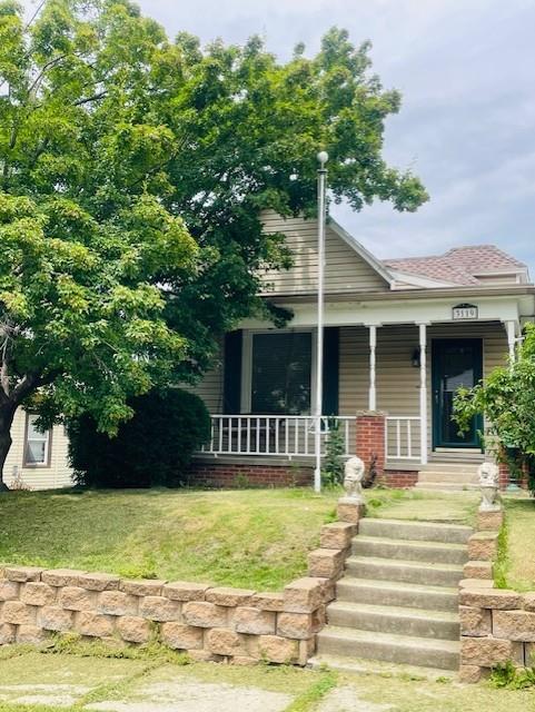 3119 Seneca St, Saint Joseph, MO 64507 - view of front of house featuring a porch, a front yard, and roof with shingles