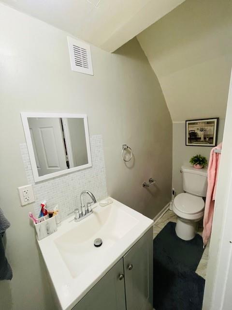 3119 Seneca St, Saint Joseph, MO 64507 - half bath with vanity, vaulted ceiling, and tasteful backsplash