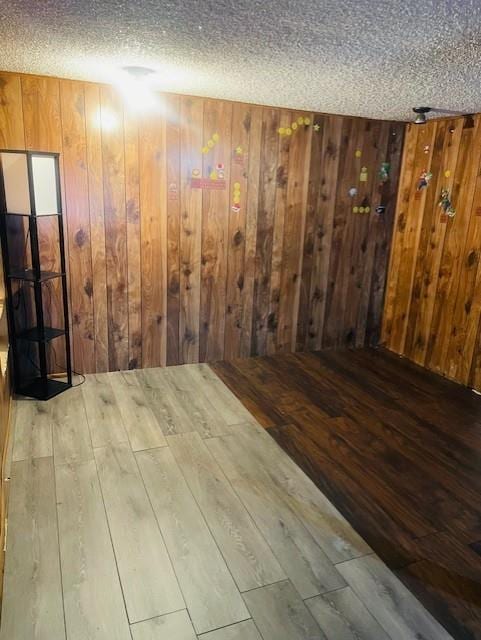 3119 Seneca St, Saint Joseph, MO 64507 - unfurnished room featuring hardwood / wood-style flooring, a textured ceiling, and wooden walls