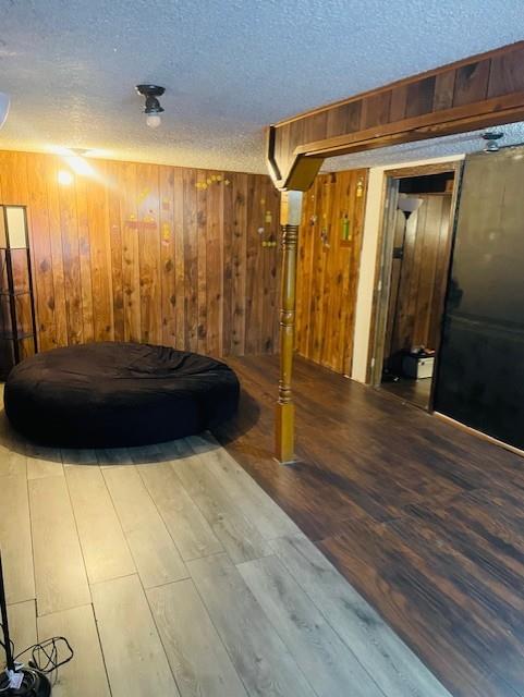 3119 Seneca St, Saint Joseph, MO 64507 - bedroom with a textured ceiling, wooden walls, and wood finished floors