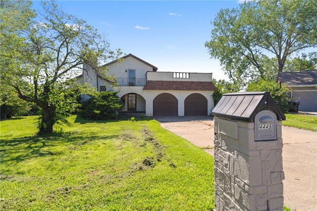 4445 NW 52nd Ter, Topeka, KS 66618 - view of front of property with a balcony, driveway, a front yard, a garage, and stucco siding