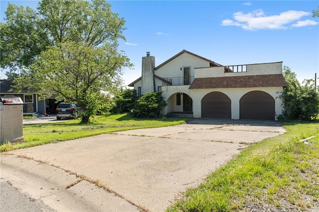 4445 NW 52nd Ter, Topeka, KS 66618 - view of front of property with a balcony, a chimney, a garage, concrete driveway, and stucco siding