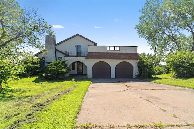 4445 NW 52nd Ter, Topeka, KS 66618 - view of front facade with a balcony, a chimney, concrete driveway, a garage, and a front lawn