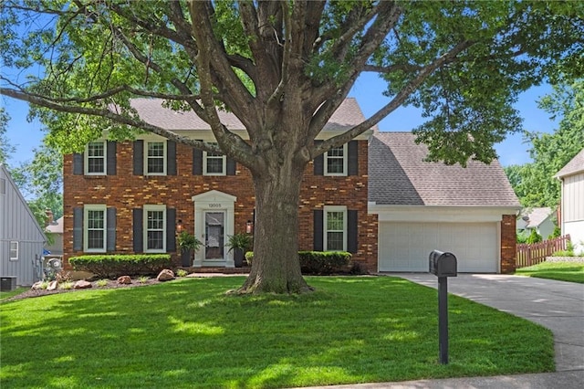 12005 W 100th Ter, Lenexa, KS 66215 - colonial inspired home with brick siding, driveway, a garage, and a shingled roof